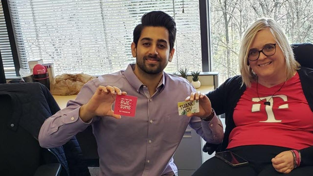 Susan Jolly and another person holding small cards in an office setting