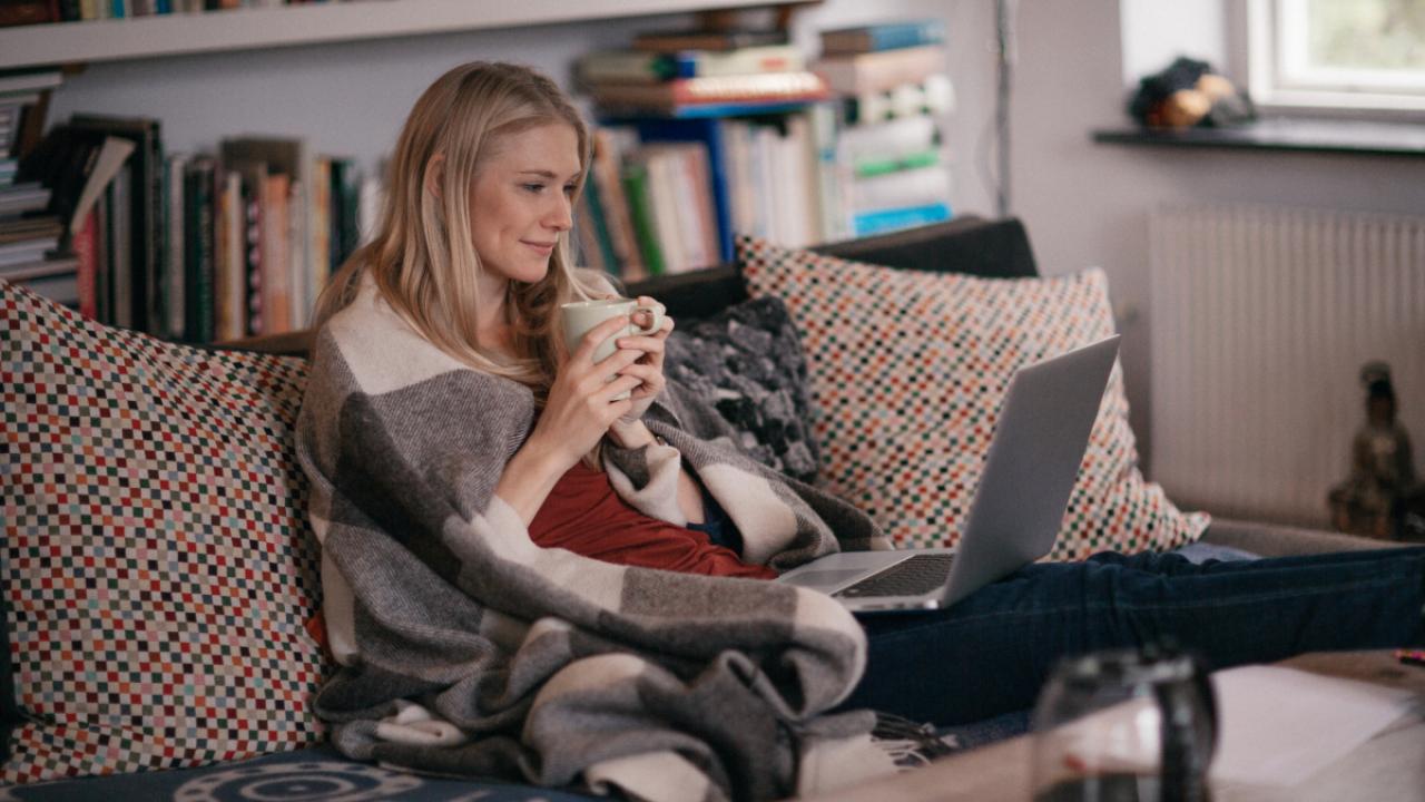 person sitting on a couch watching a laptop