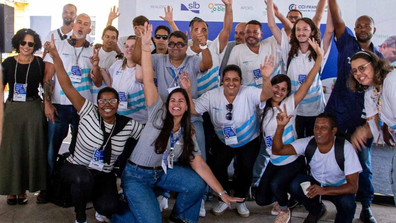 A group of people smiling and raising their arms