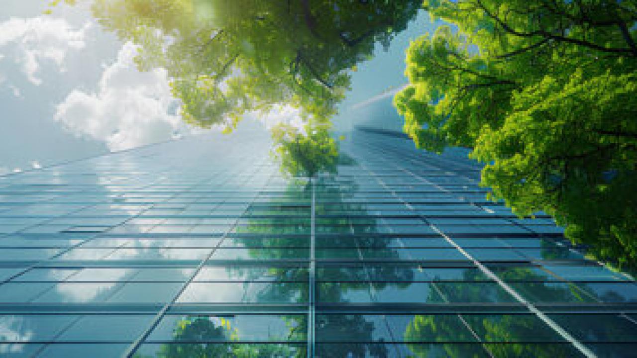 ground view of a glass building with trees and clouds