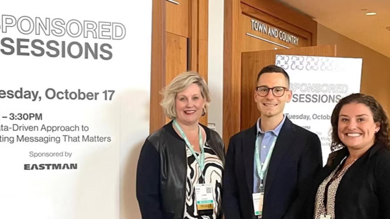 Three people stood in front of "Sponsored sessions" event banner