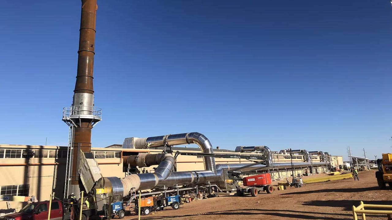 A large industrial plant, a clear blue sky behind.