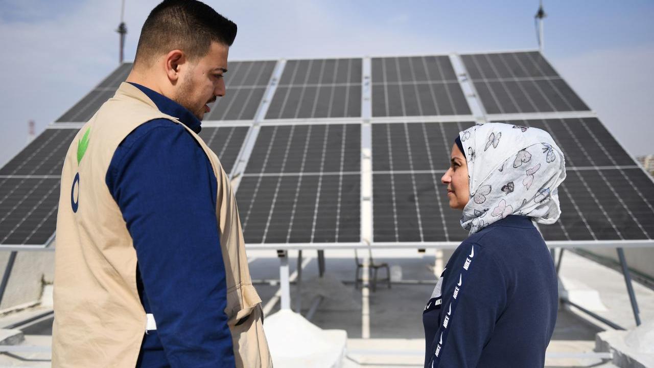 Action Against Hunger's Abdul Kareem, 28, works on a solar electricity project with Amira, the manager of a local school in Aleppo.