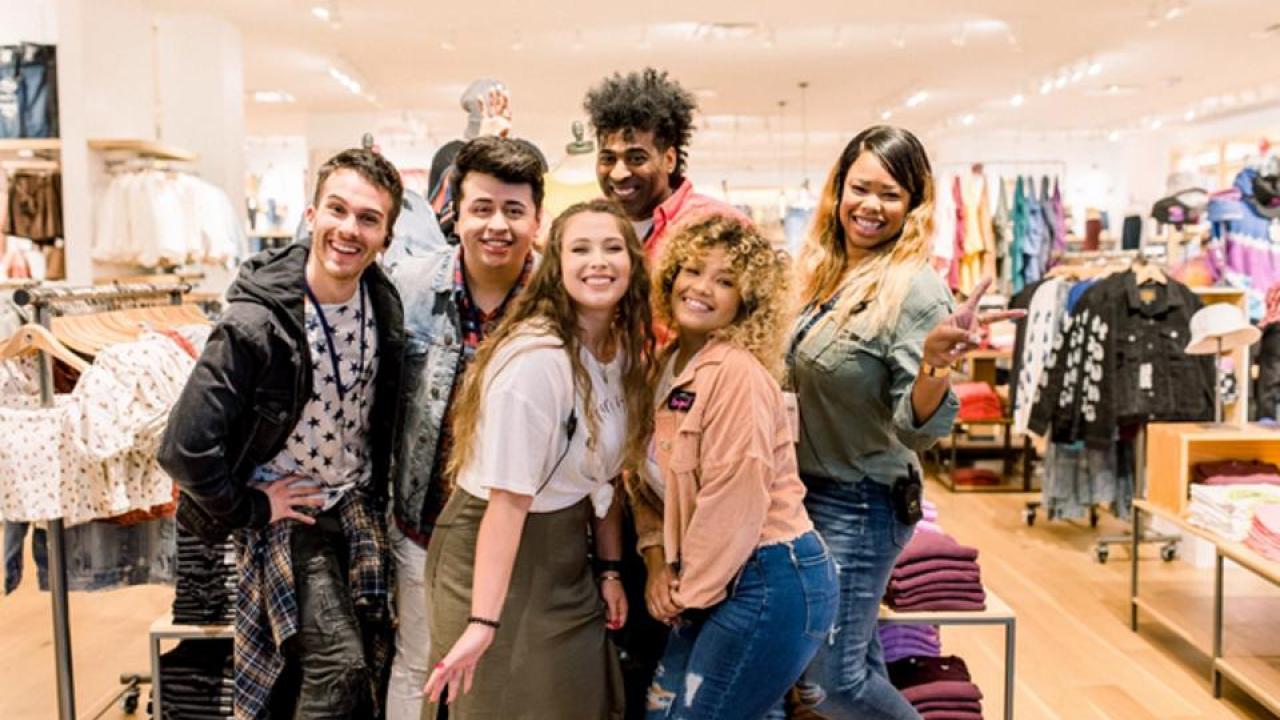 6 people standing together in a clothing store