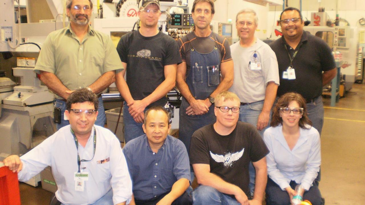 Team of employees posed in a warehouse setting.