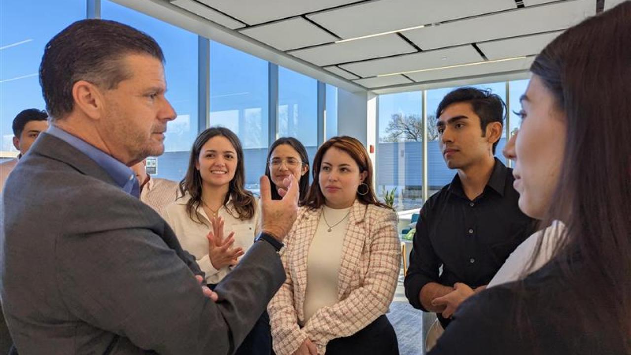 Person speaking to a small group in an office setting.