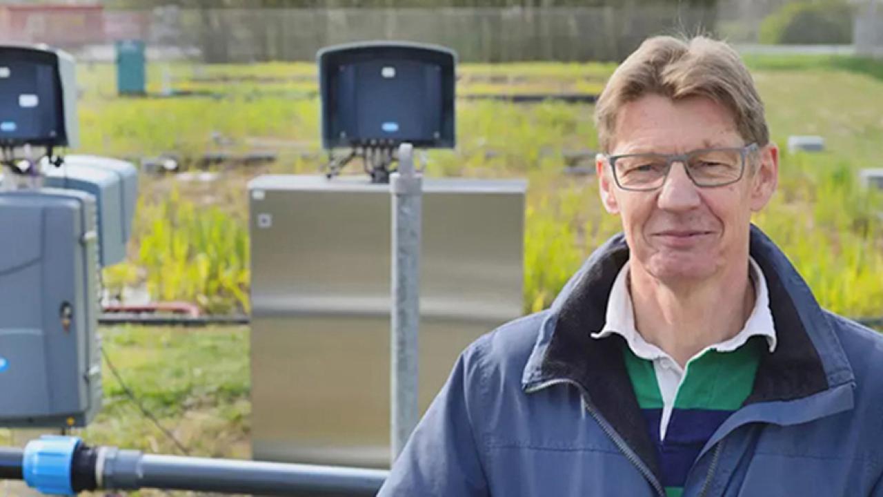 person standing in front of a field with piping and equipment