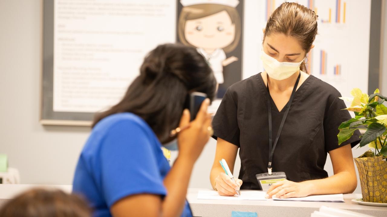 Two health care workers at reception desk