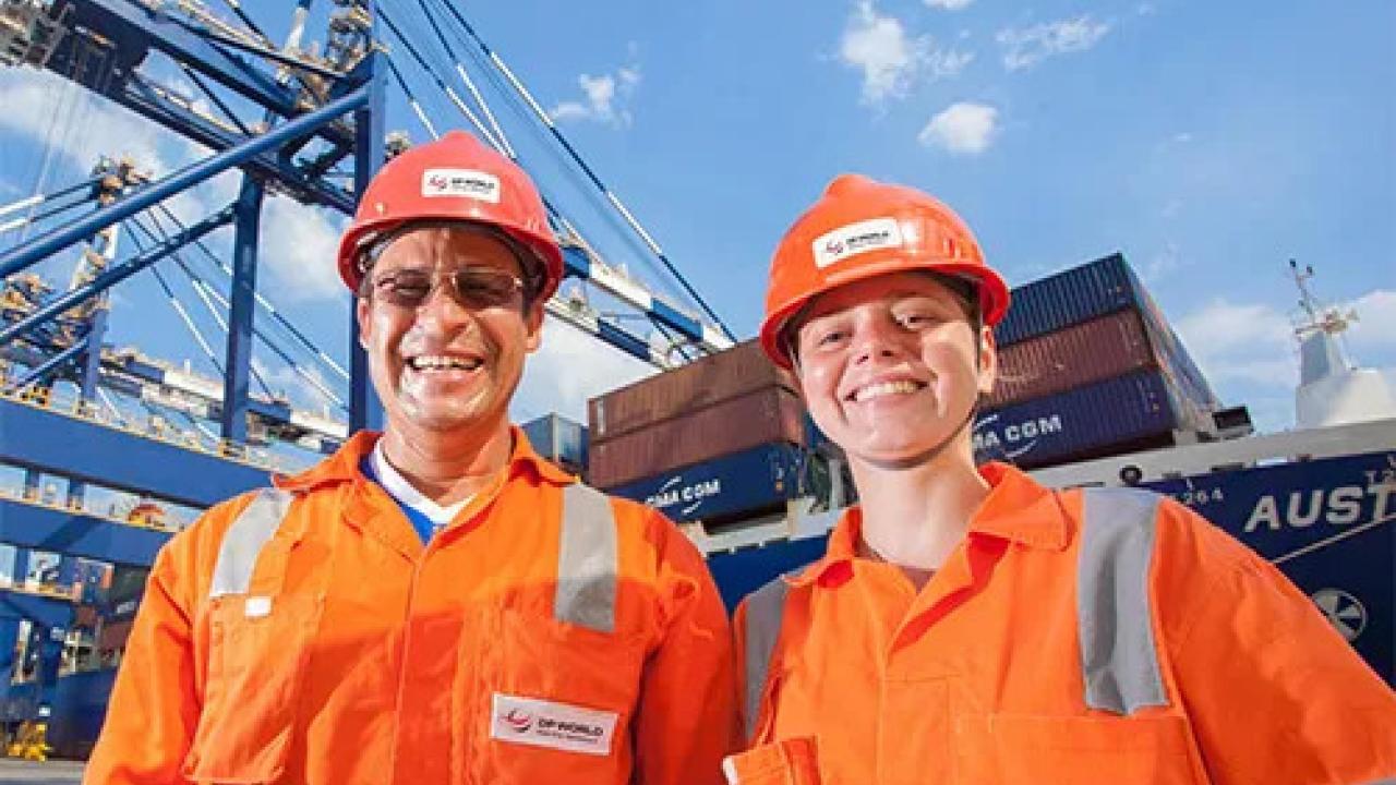 Two DP World employees in uniform at a shipping transfer yard.