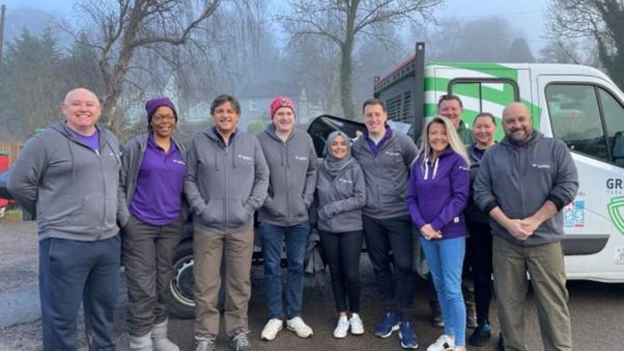 A group of volunteers posed outside in front of a truck.