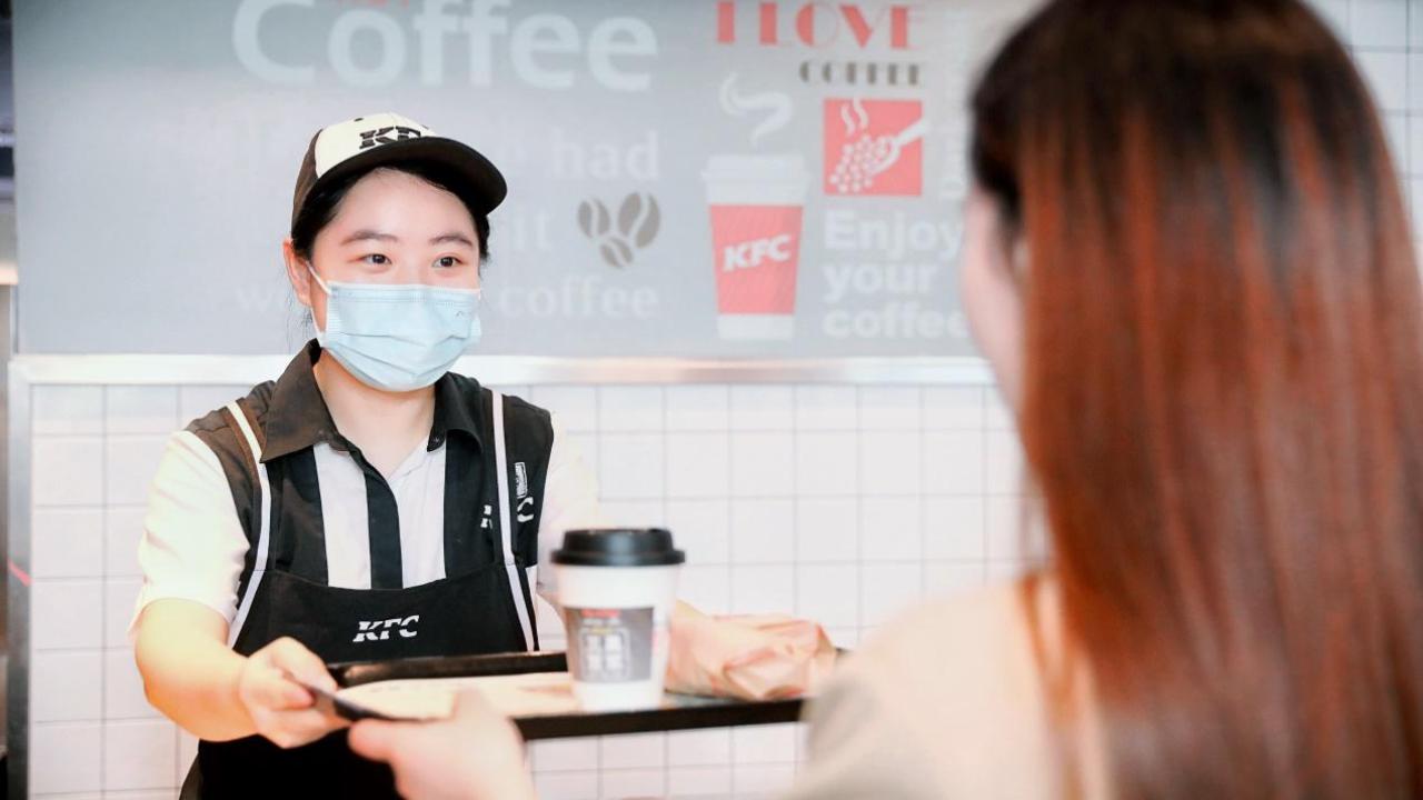 KFC employee with drink on a tray