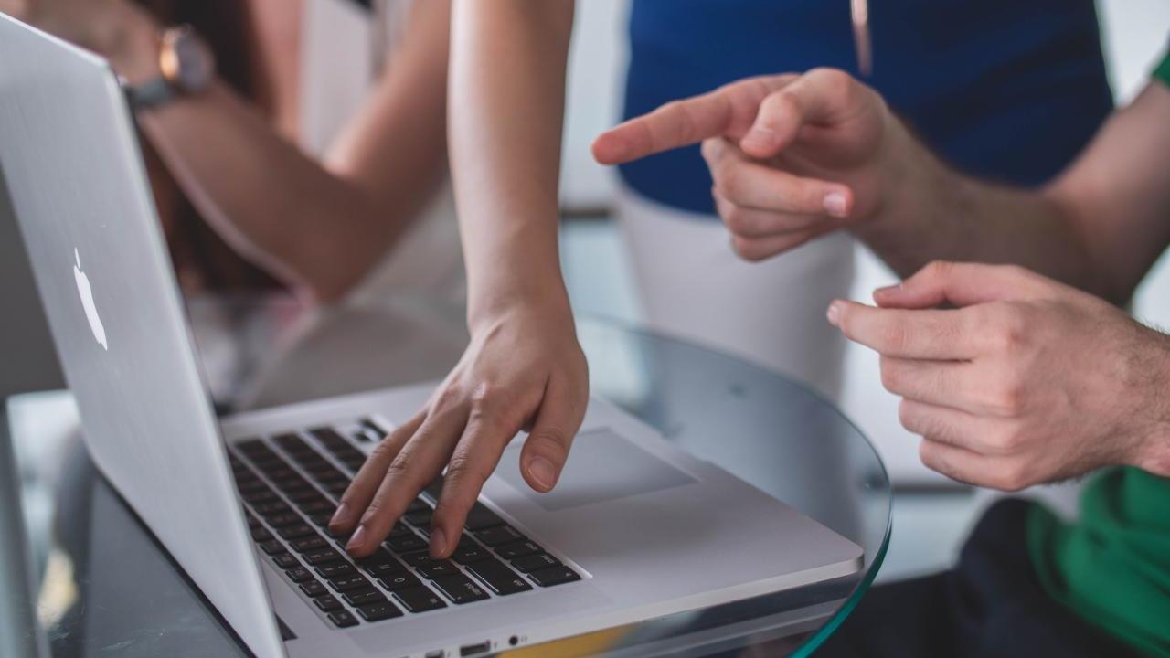 people's hands in front of laptop