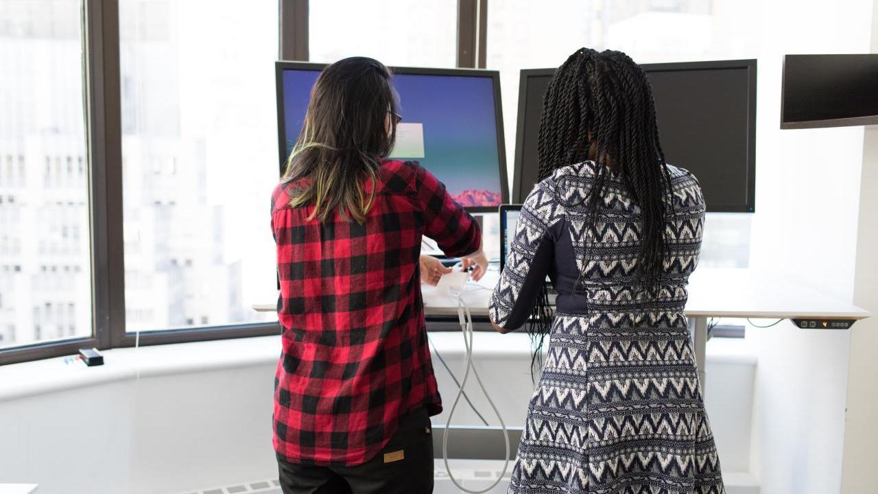 two people standing in front of computers