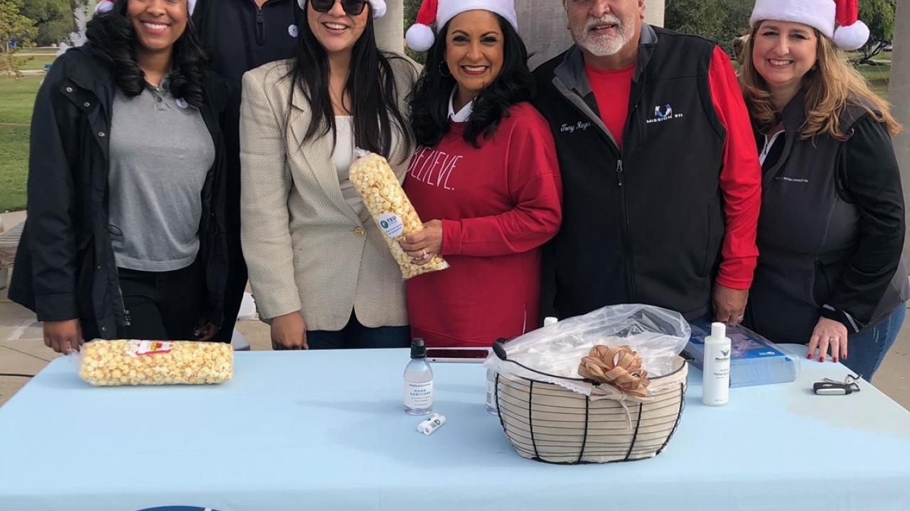 TXU energy table with 6 people with Santa hats