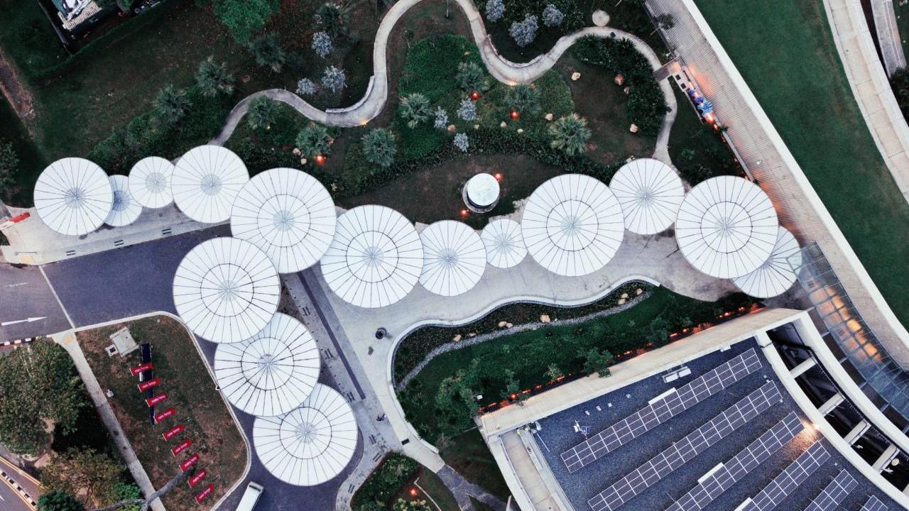 Aerial view of building and many circular objects along a path.