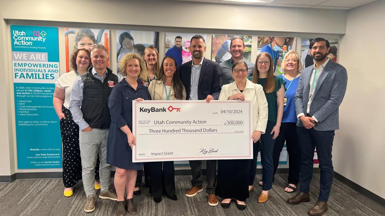 People standing together holding a large check