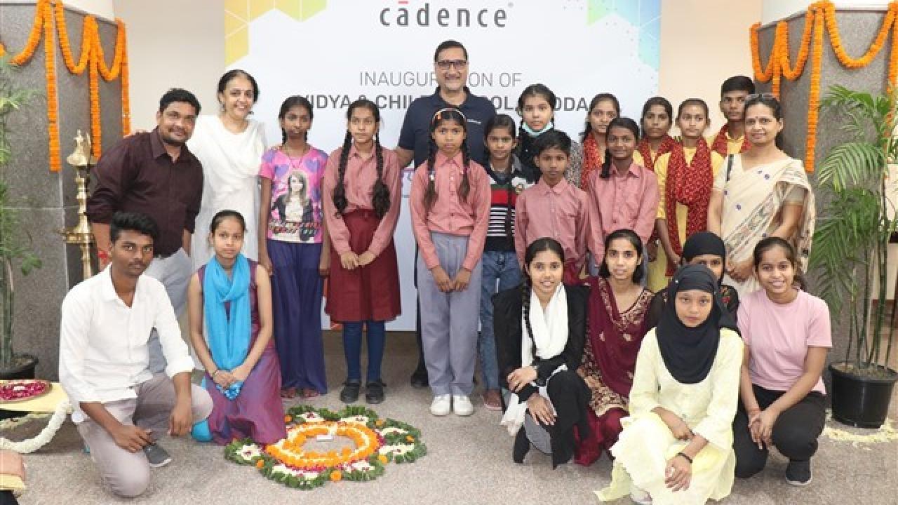 A group of children and adults in front of a sign for Cadence.