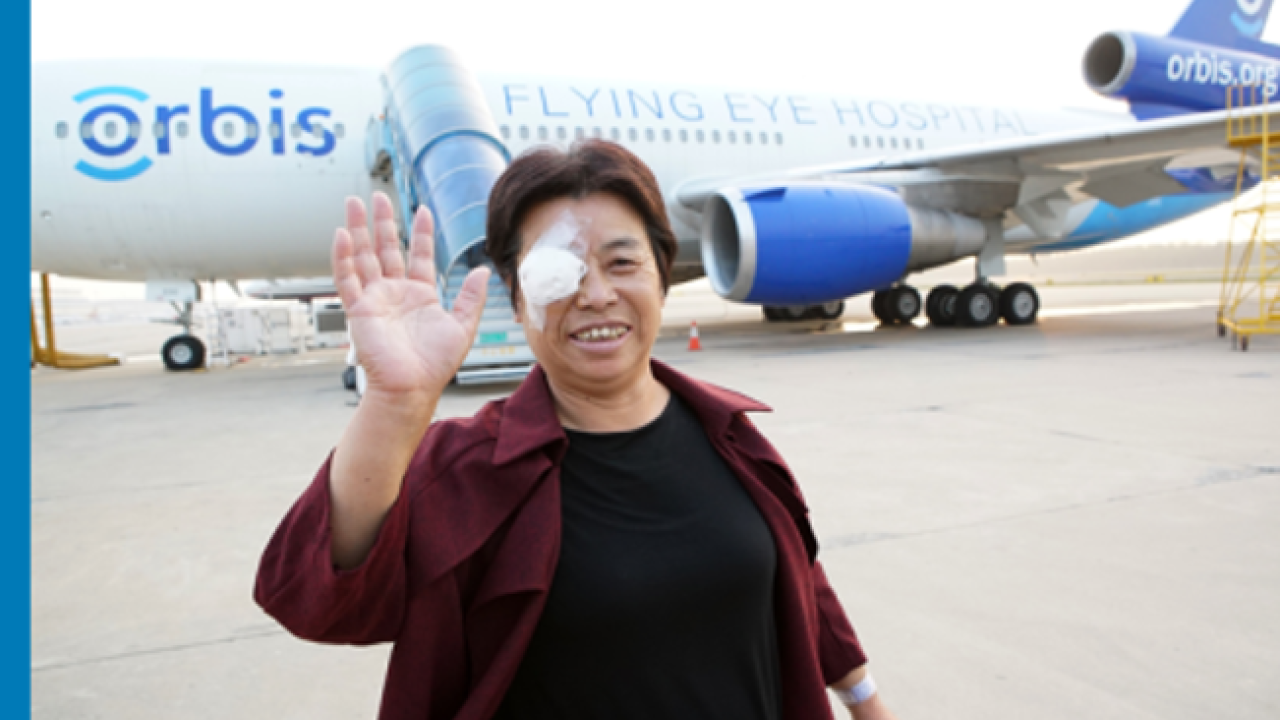 Patient smiling with eye patch outside of the Orbis plane