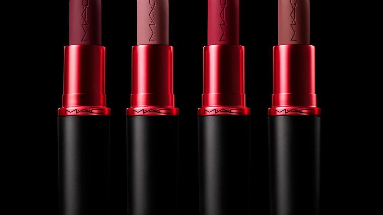 Four different color lipsticks on a black background
