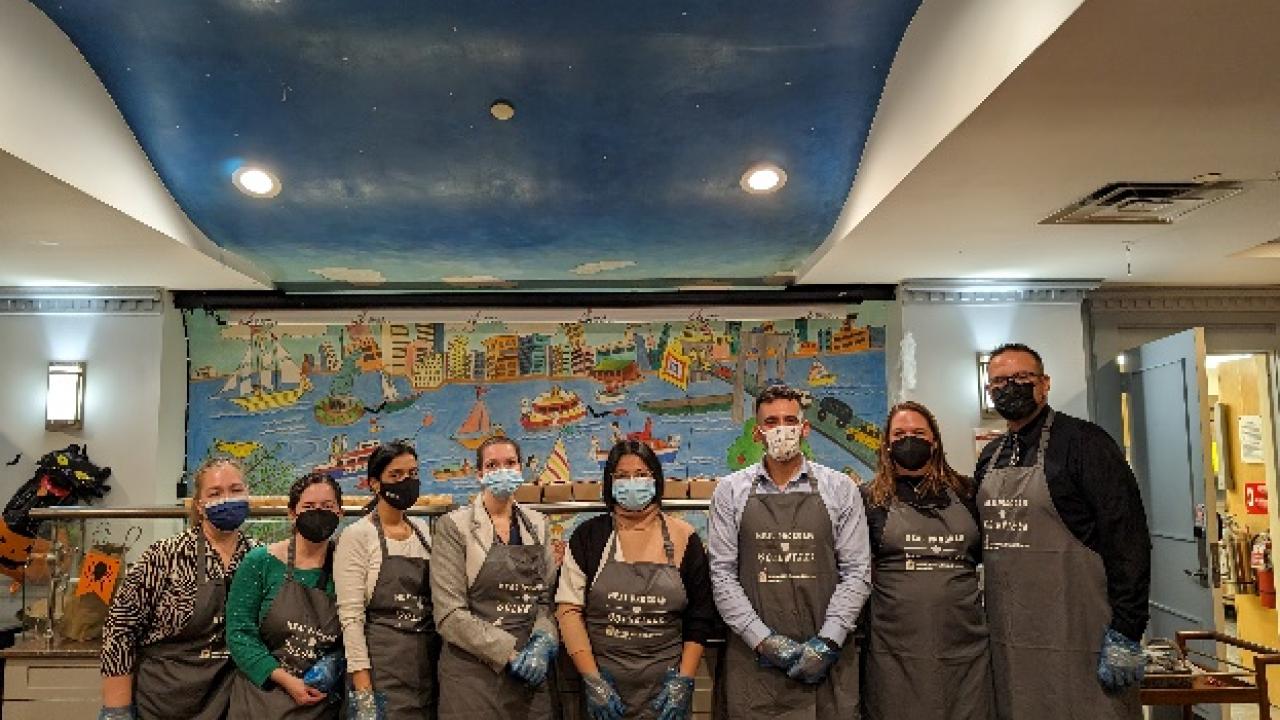 A group of volunteers posed wearing matching aprons.