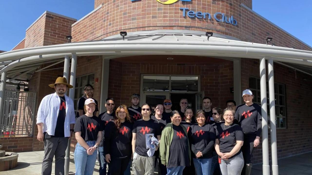 A group of volunteers in matching tshirts in front of a building "Chops tech club