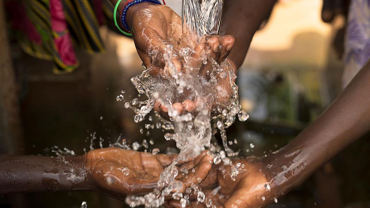 Stream of water pouring into children’s hands in southern Burkina Faso.