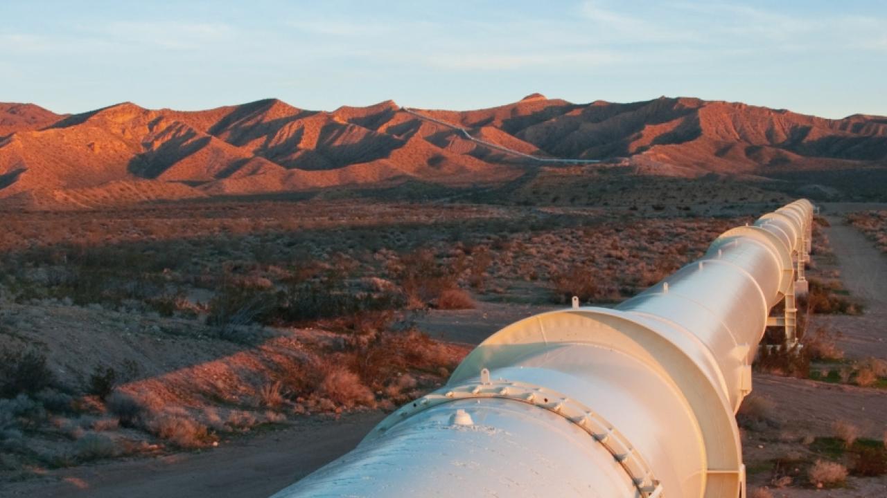 a large pipeline through a desert and mountain landscape