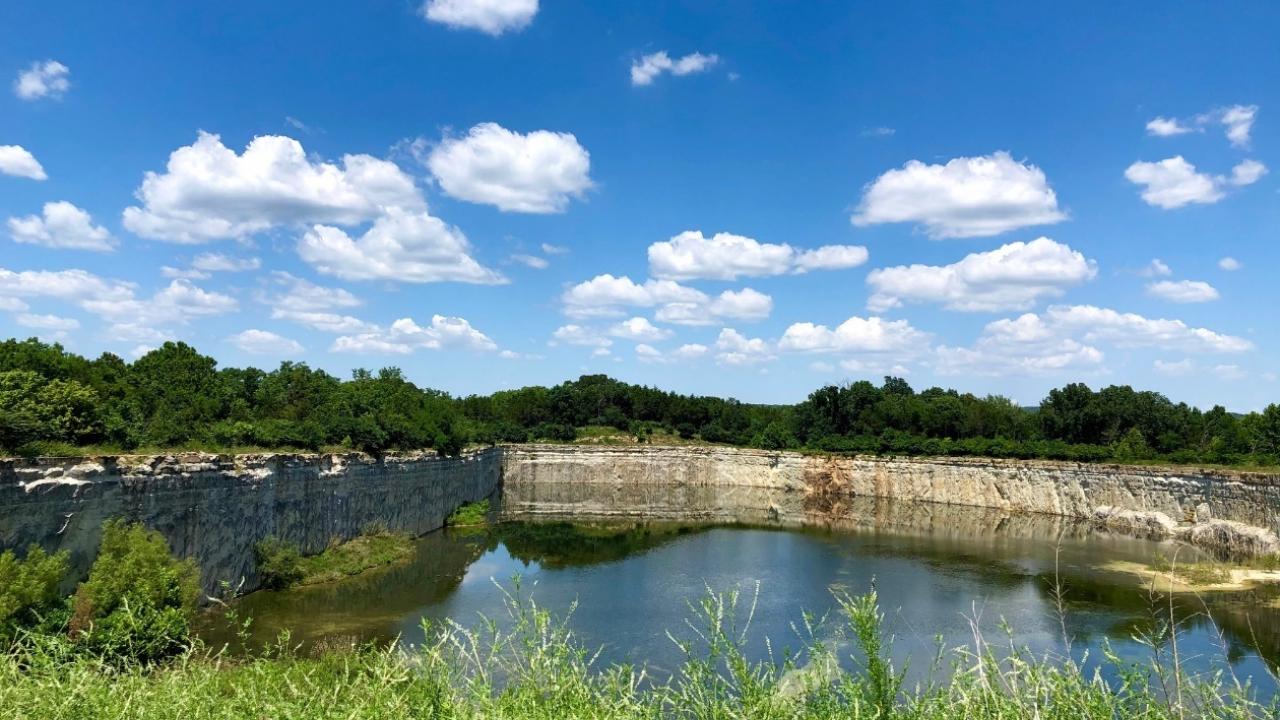 A scenic view of a body of water in a green area.