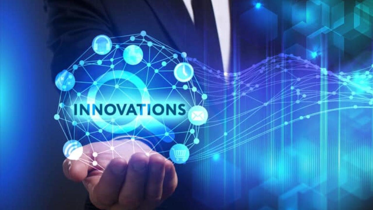 person holding a drawing of an orb with word "INNOVATIONS"