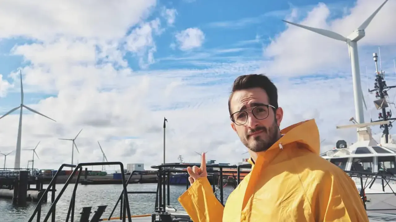 Ruggero Rollini in a rain jacket pointing to the clouds