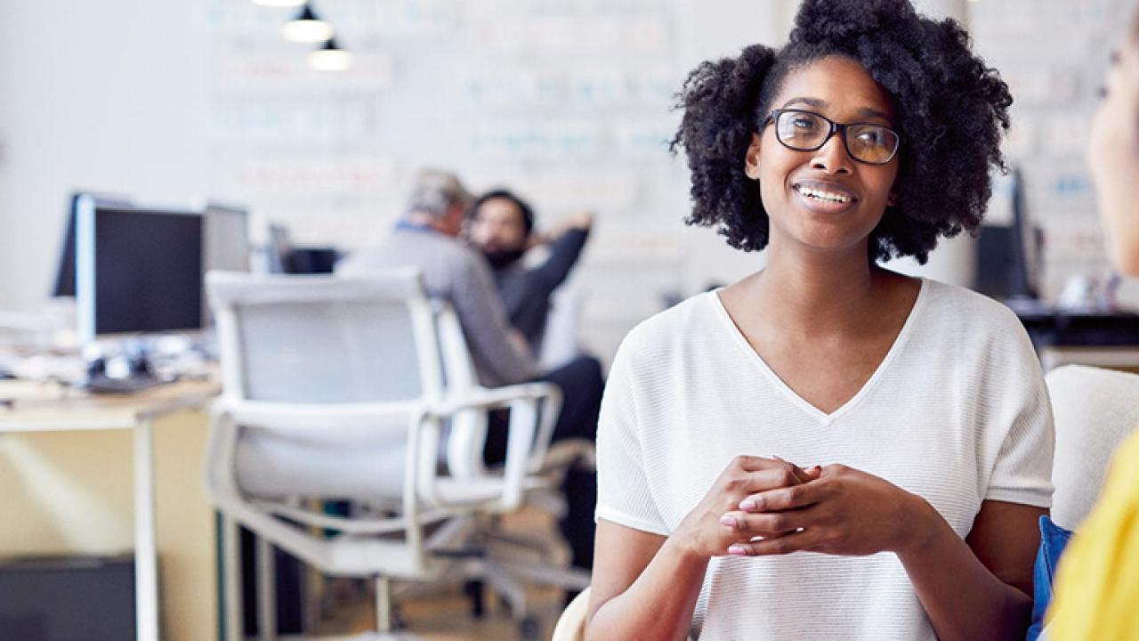 Two people talking in an office setting.