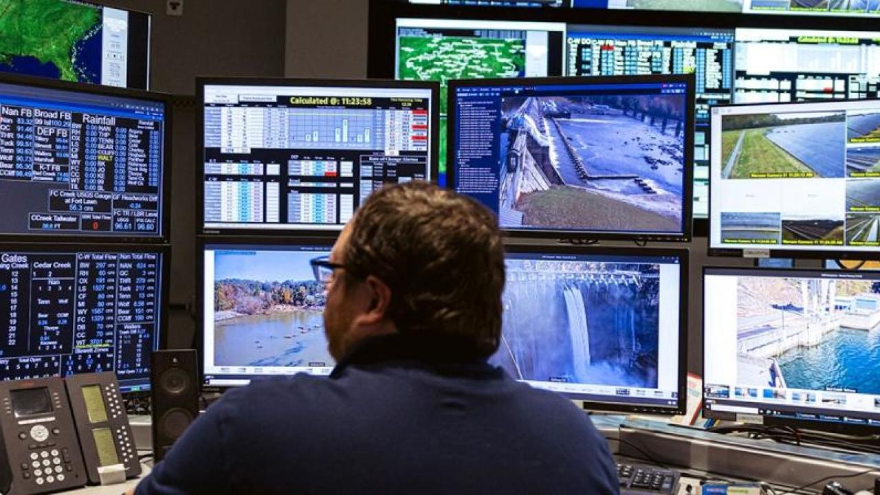 Someone sitting in front of many screens