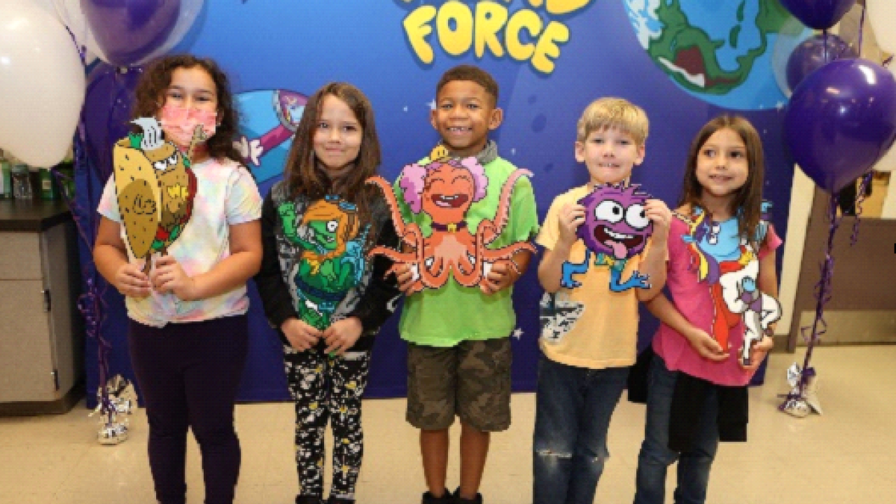 Five kids with crafts in front of "Word Force" banner