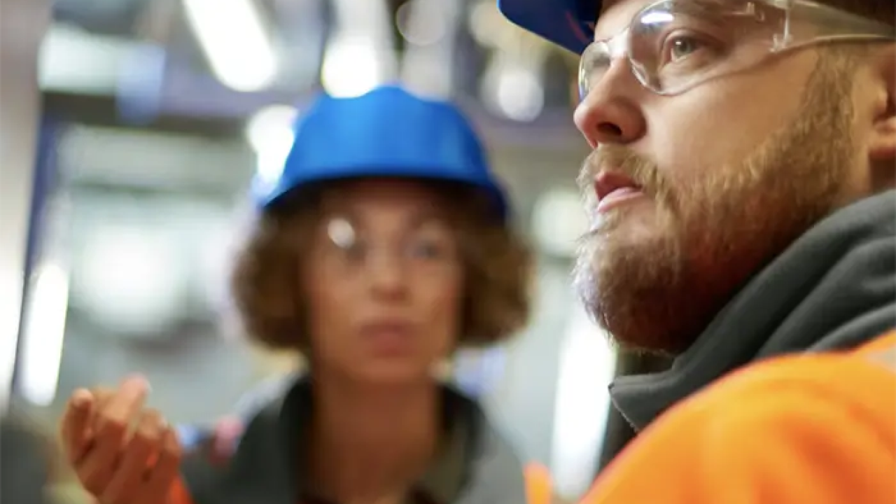 2 people wearing hardhats and safety glasses