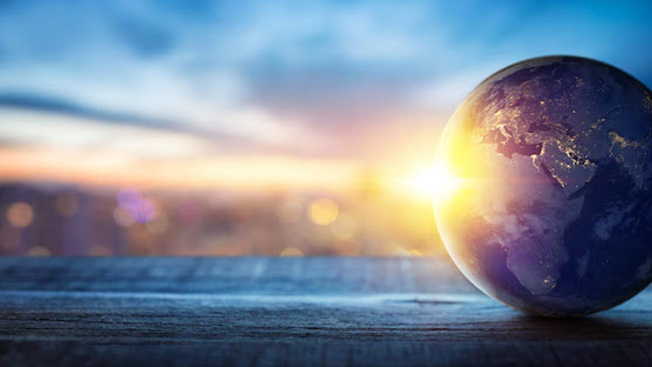 Model of the Earth sitting on a shelf with sunlight reflecting on the front of the globe.