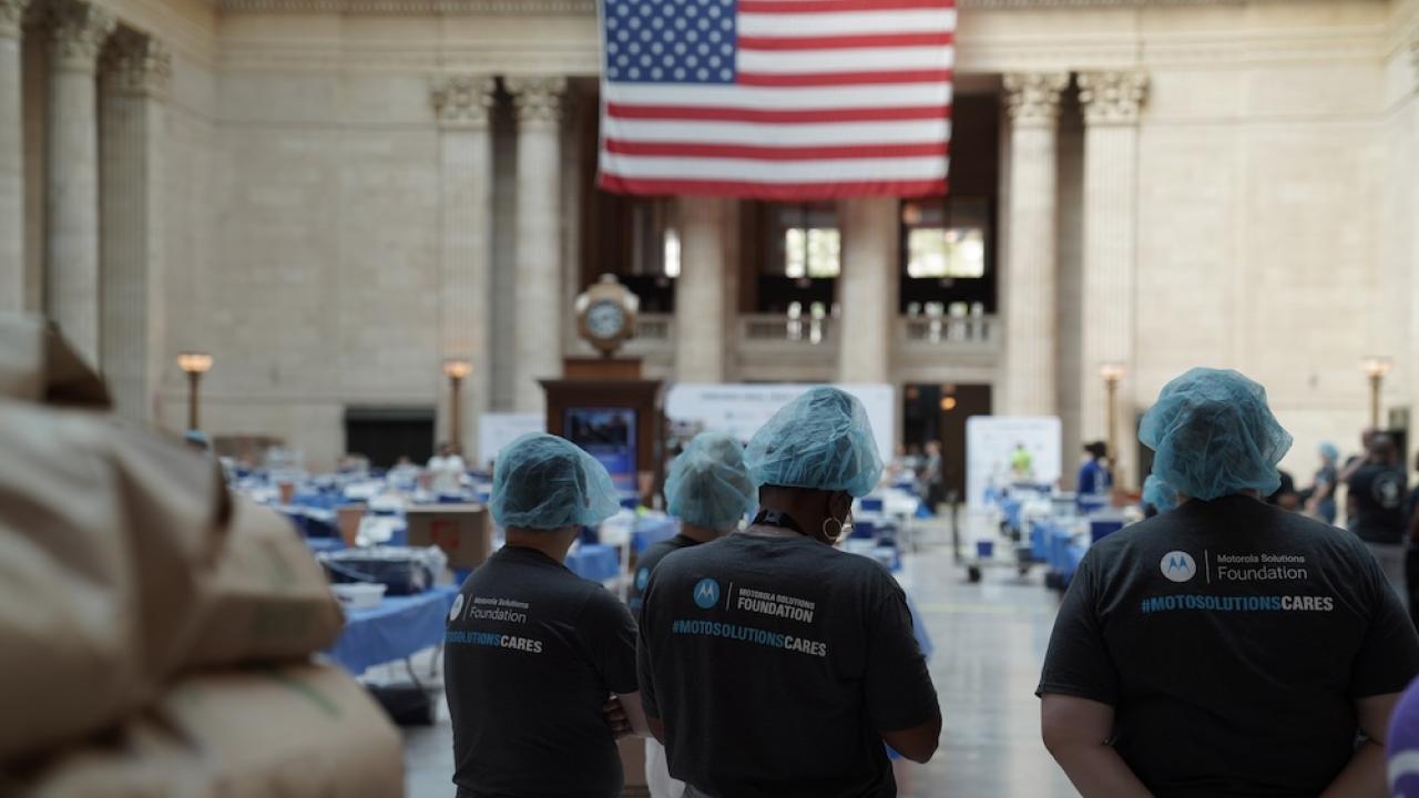 Volunteers standing by flag