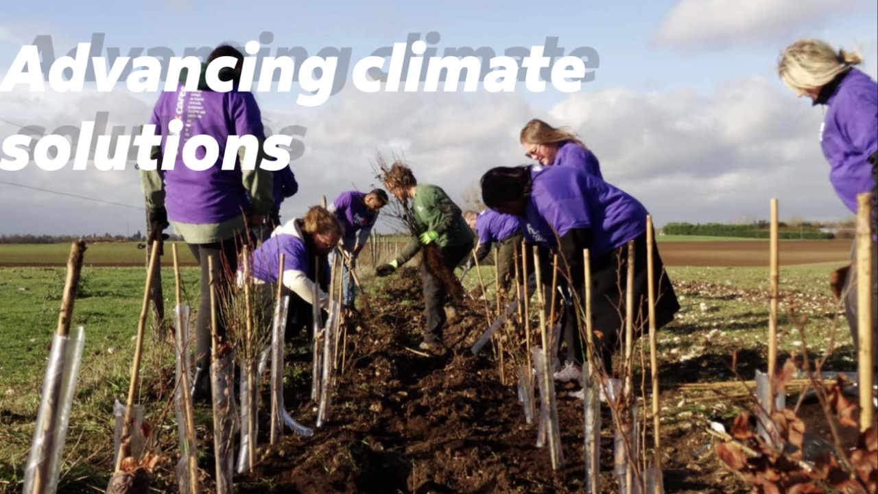 "Advancing climate solutions" with picture of people planting together