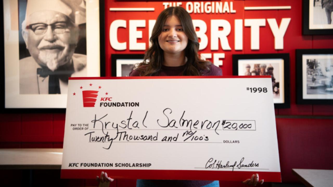 Scholarship recipient holding up check