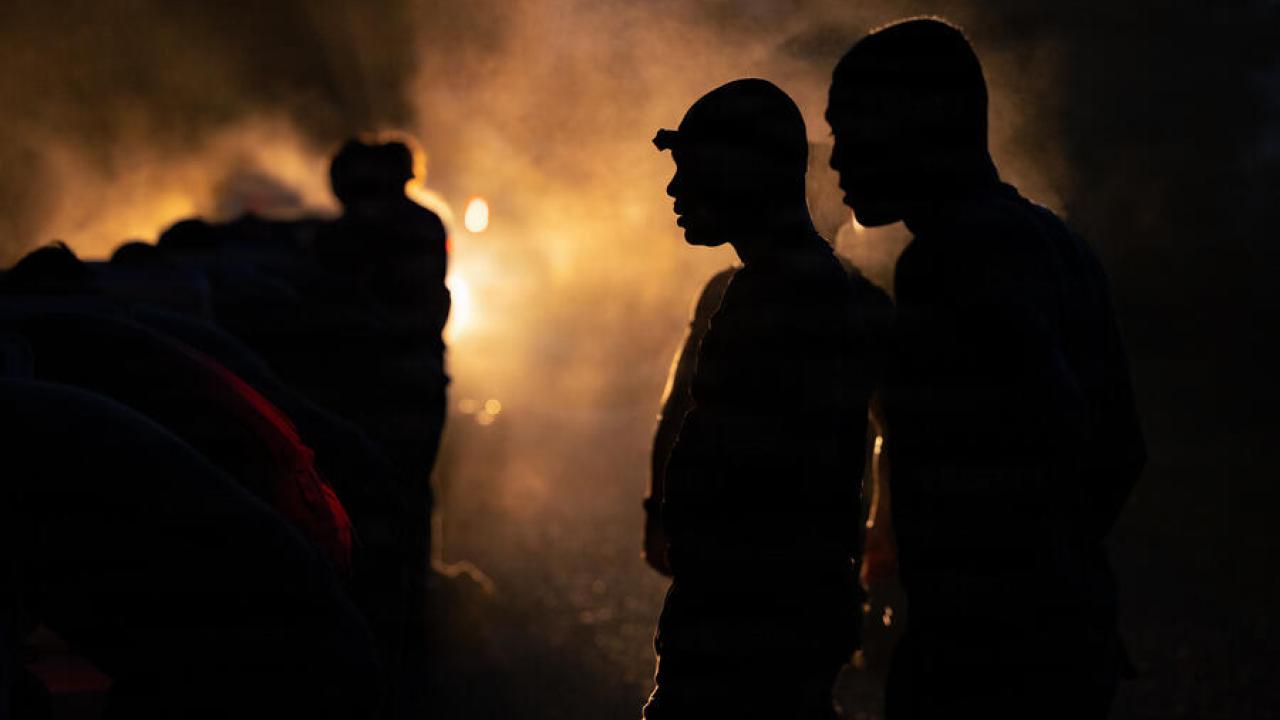 group of people standing in the dark with one light