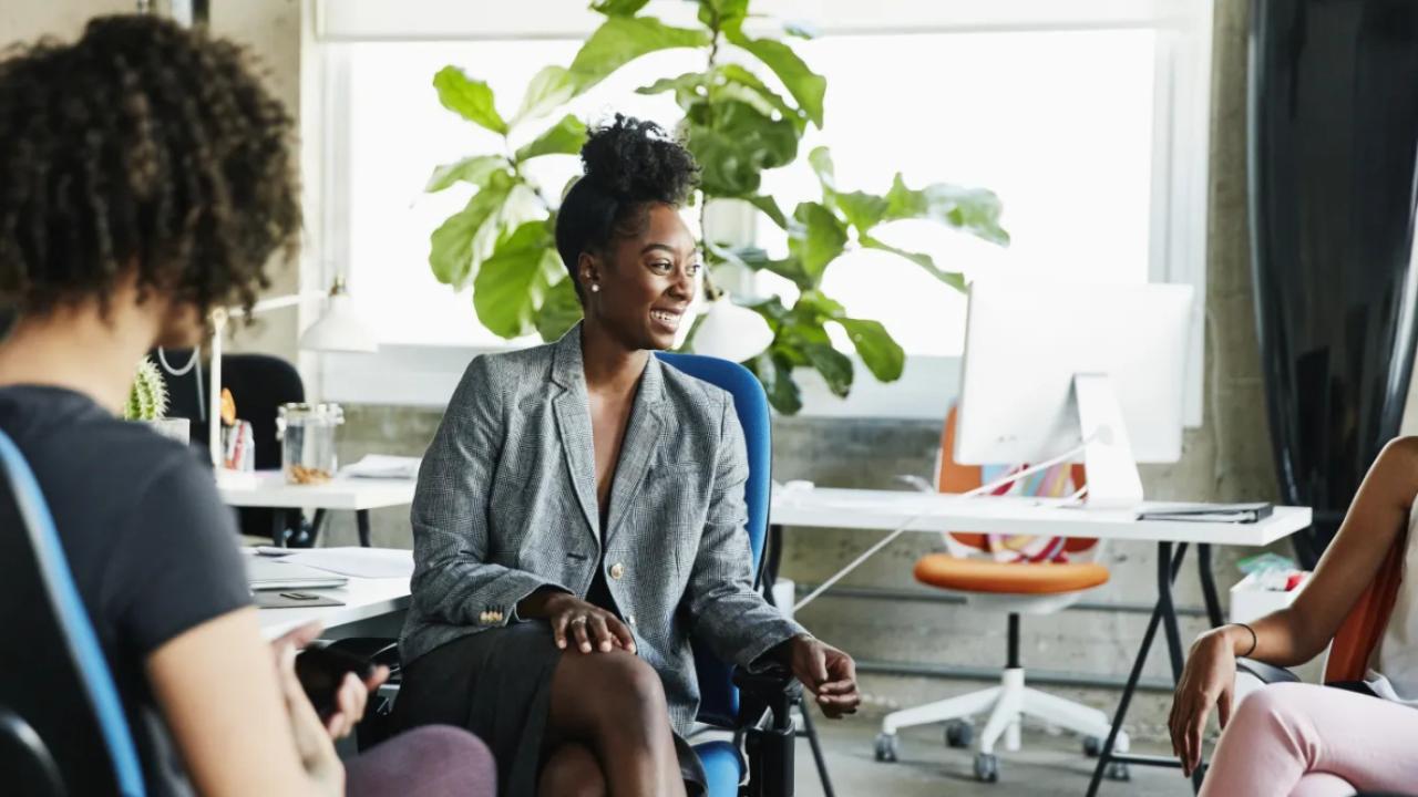 Office meeting with three women seated in an open environment