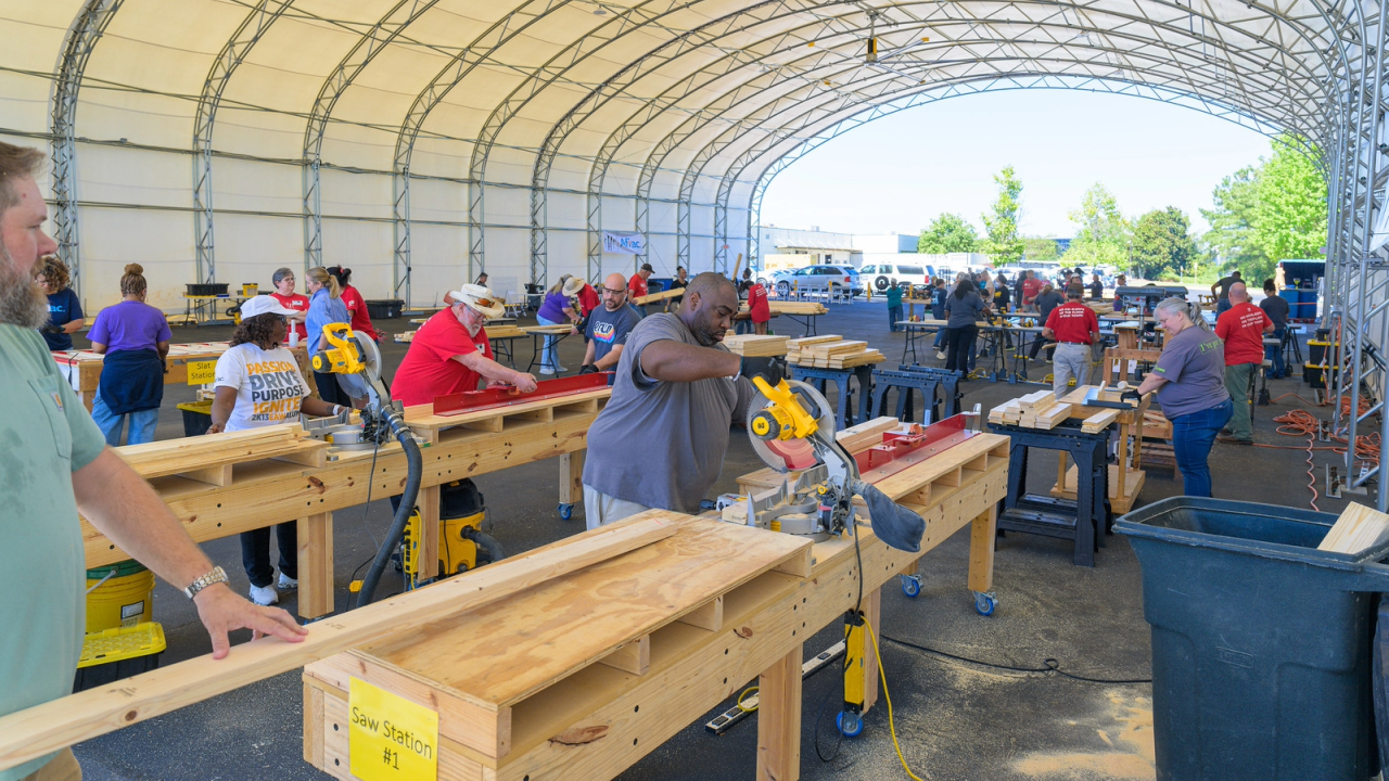 Aflac volunteers building beds in a hanger.