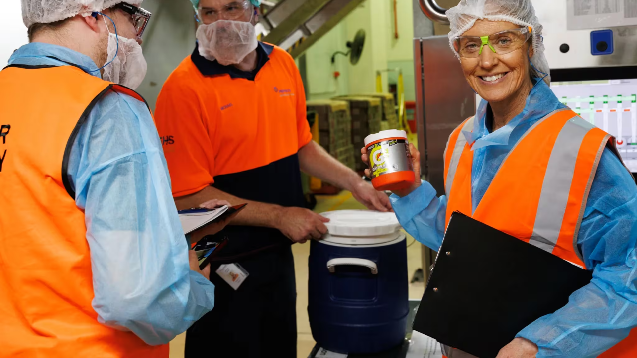 three people working in an industrial facility