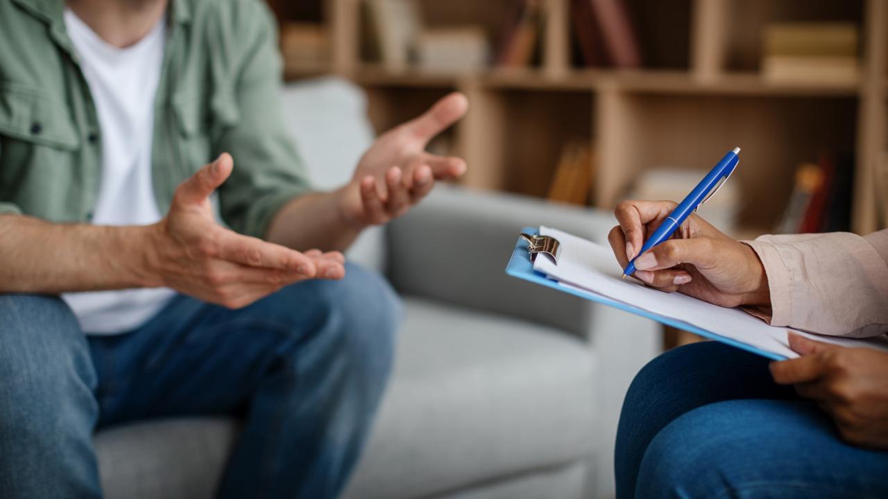 Two people conversing, one is writing on a clipboard