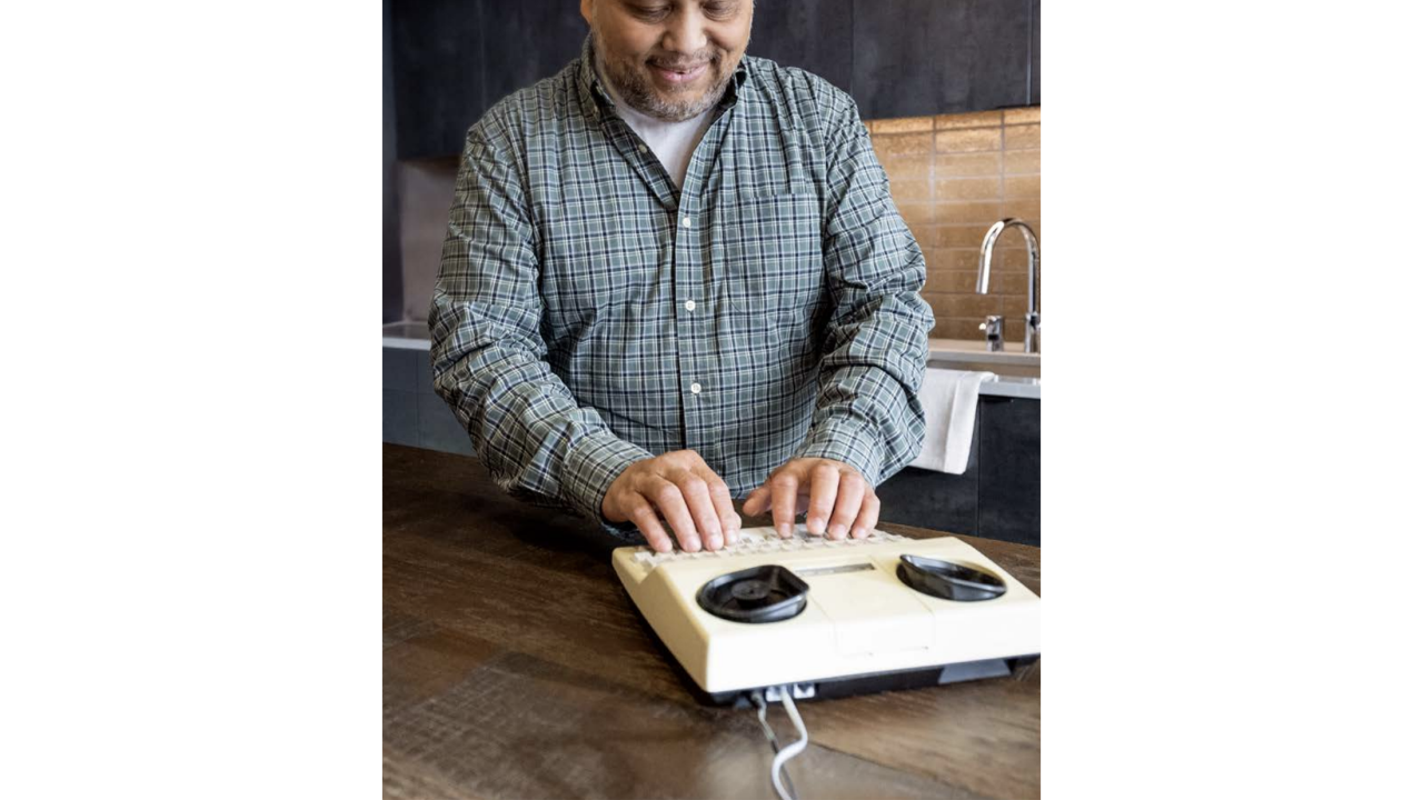 man typing on an assistive device 