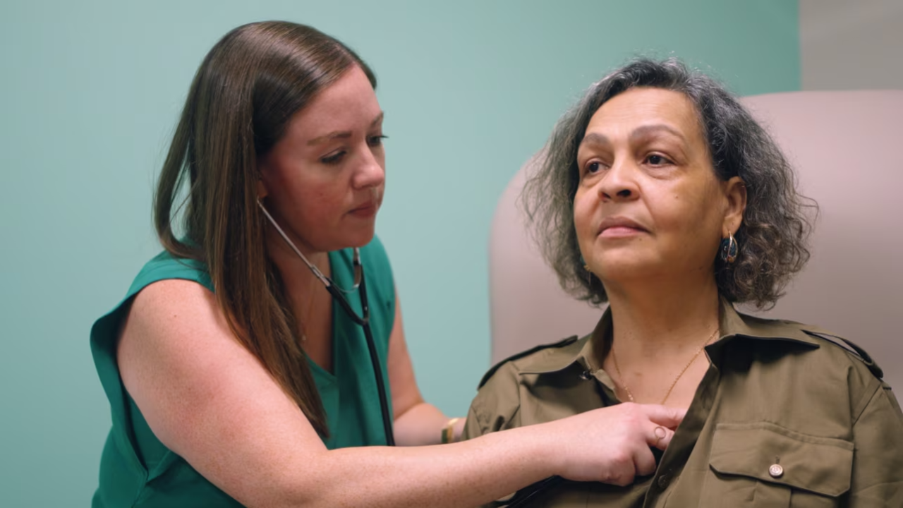 Healthcare worker listening to a patient's heart with a stethoscope