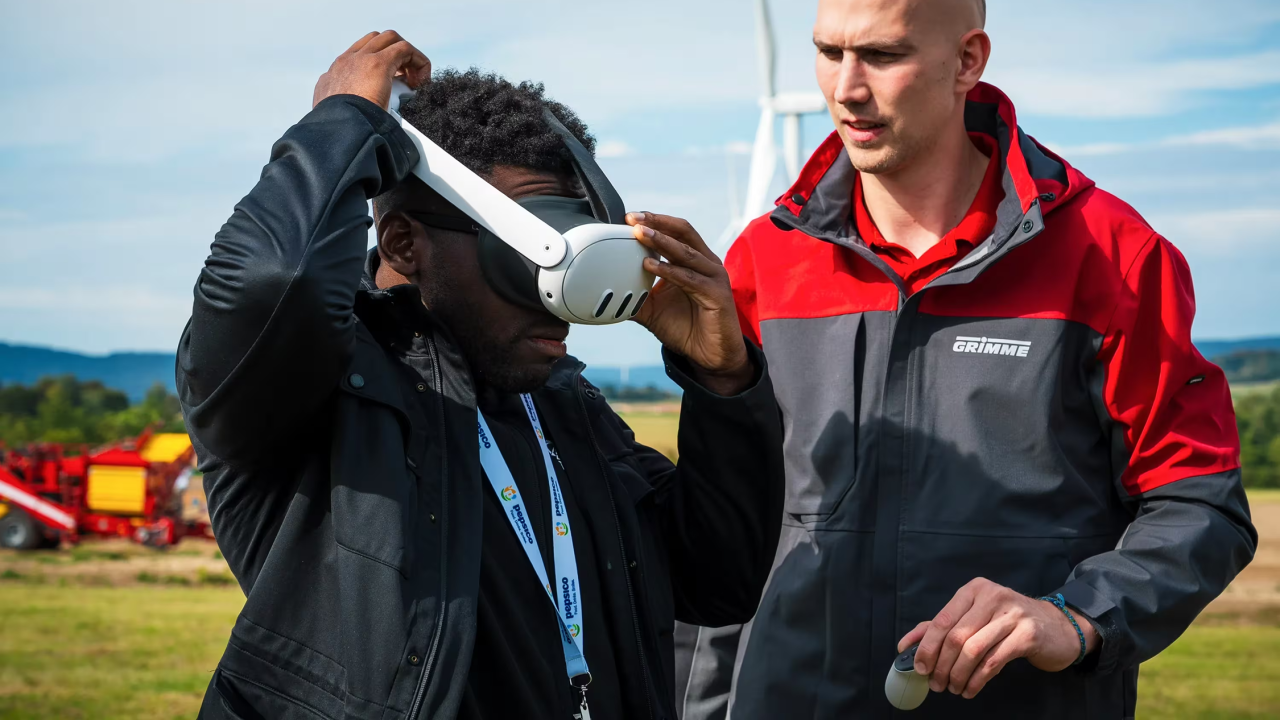 someone putting on a virtual headset while another looks on