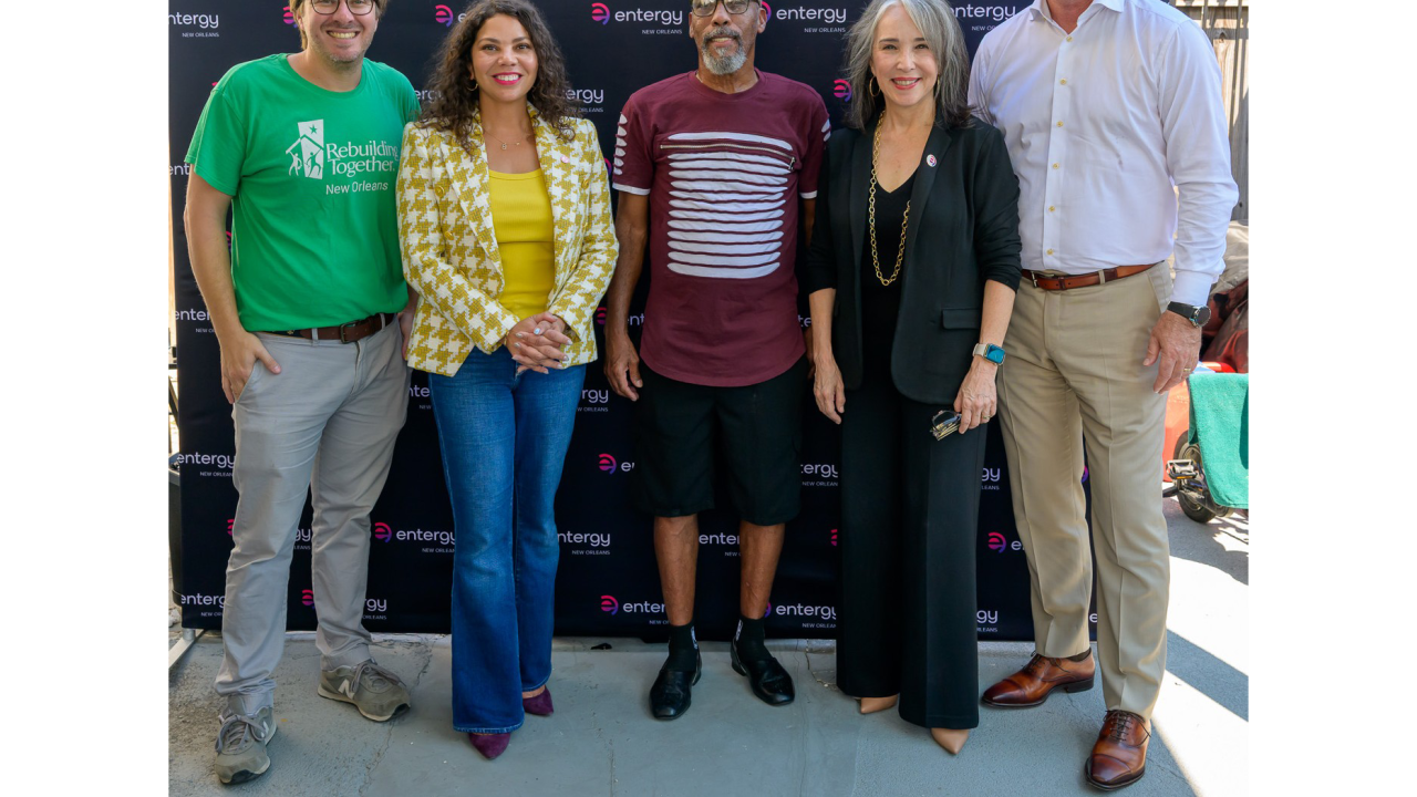 Five people standing together in front of an Entergy New Orleans backdrop