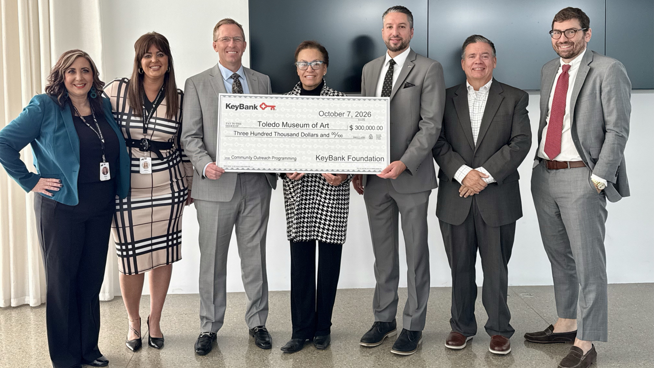 a small group posing with an oversized check