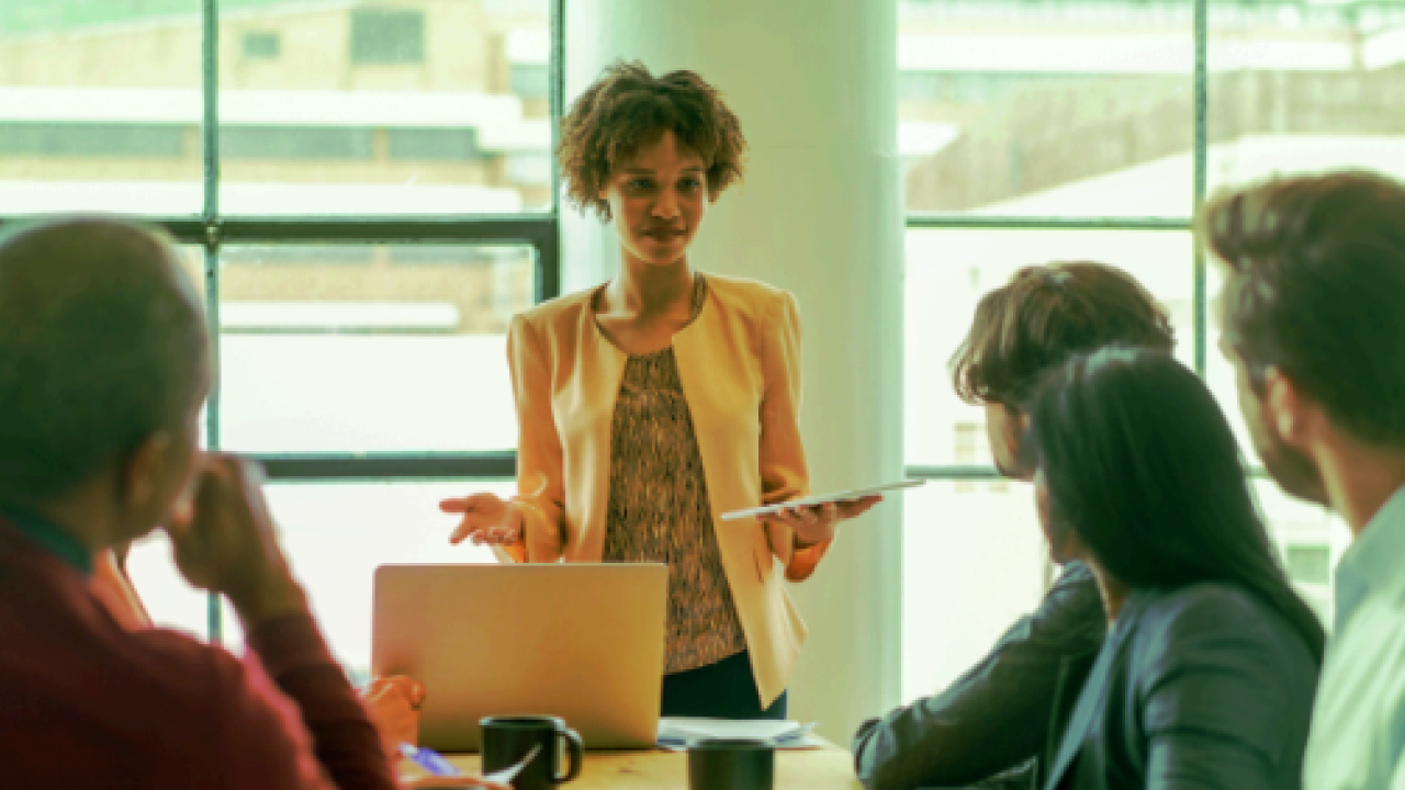 Woman talking to people in board room